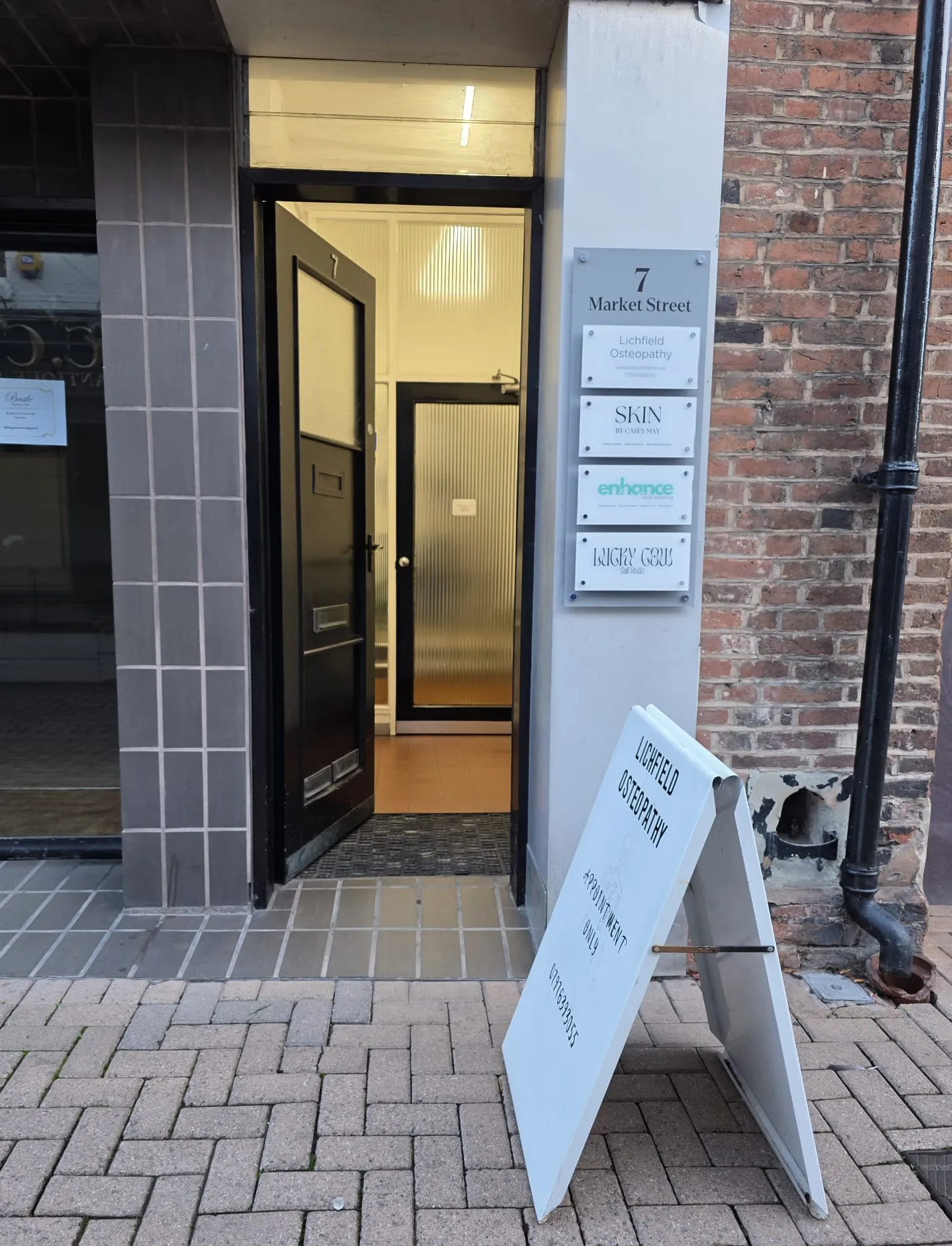 The black front door of 7 Market Street, with the Lichfield Osteopathy sign beside it and the white A-board on the pavement